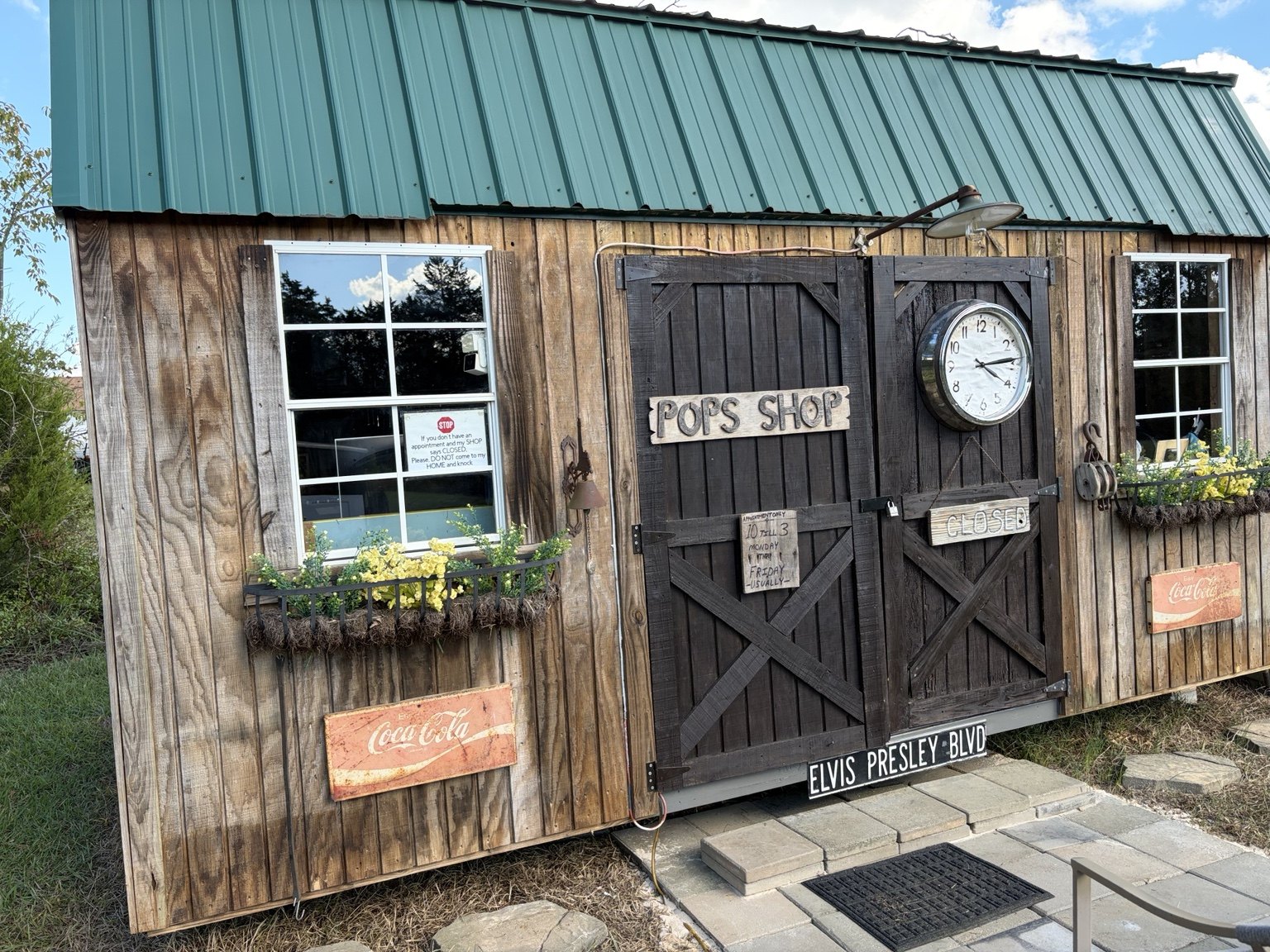 The weathered wooden exterior of Pop’s Shop, with its clock and hand-lettered sign